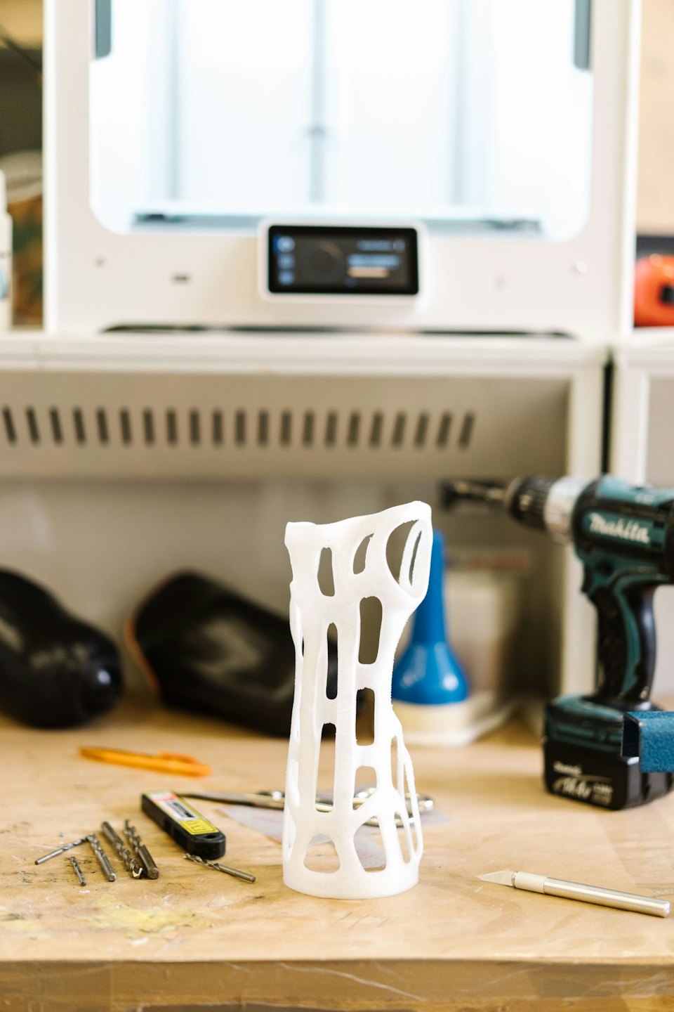 Ortesis impresa en 3D sobre un banco de trabajo con herramientas.