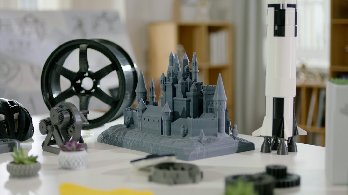 Varios objetos impresos en 3D sobre una mesa blanca.